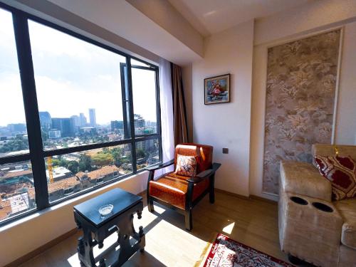 a living room with a chair and a large window at Stone Age Nairobi --- Rooftop Pool & Lounge, Gym, Games room, Office Space in Nairobi