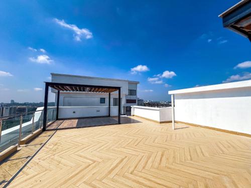 a balcony with a wooden floor and a blue sky at Stone Age Nairobi --- Rooftop Pool & Lounge, Gym, Games room, Office Space in Nairobi