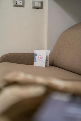 a piece of paper sitting on top of a couch at MagentA NesT - Loft&Charme in Brescia