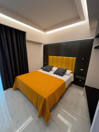 a bedroom with a large bed with a yellow blanket at Luxury Home Station in Tropea