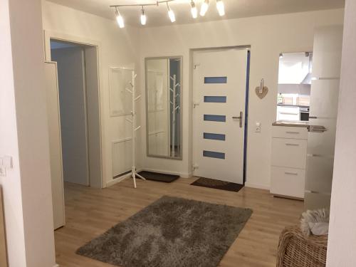 a white room with two doors and a rug at Schöne FeWo im Illertal in Oberopfingen