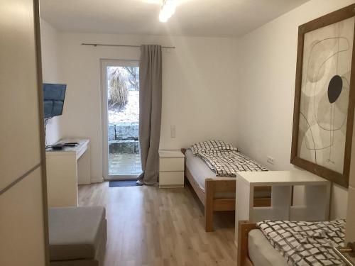 a small room with two beds and a window at Schöne FeWo im Illertal in Oberopfingen