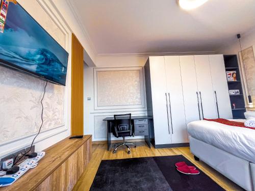 a bedroom with a bed and a desk with a chair at Stone Age Nairobi --- Rooftop Pool & Lounge, Gym, Games room, Office Space in Nairobi
