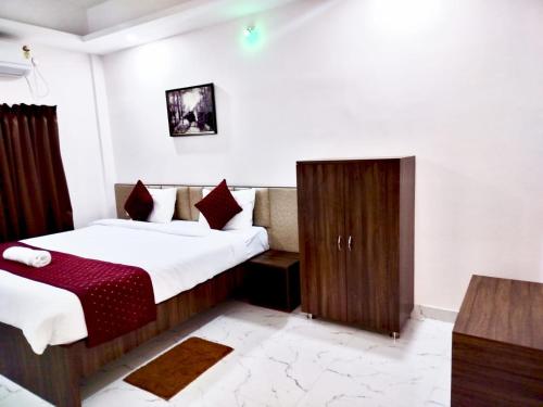 a hotel room with two beds and a cabinet at Divine Homestay in Siliguri
