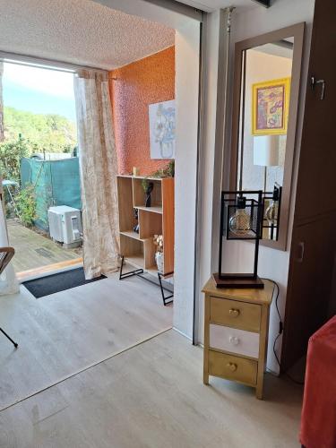 - un salon avec une porte s'ouvrant sur une terrasse dans l'établissement Mimilou Eleuthera 500 metres du centre naturiste, au Cap d'Agde