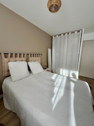 une chambre avec un grand lit blanc et une fenêtre dans l'établissement Magnifique T3 tout équipé, à Port-de-Bouc