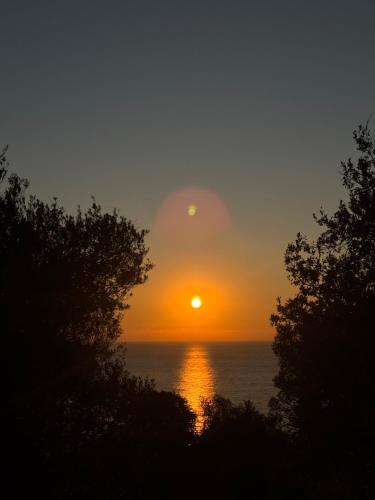 a sunset over the ocean with the sun in the sky at Room with amazing sea view in Himare