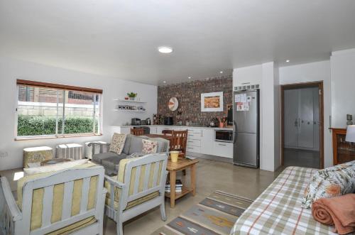 a living room with a couch and a kitchen at Kariza in Yzerfontein