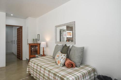 a bedroom with a bed with a plaid blanket at Kariza in Yzerfontein