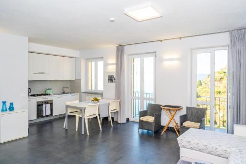 a kitchen and living room with a table and chairs at Luxury Seaview Apartments Manarola by Arbaspàa in Manarola