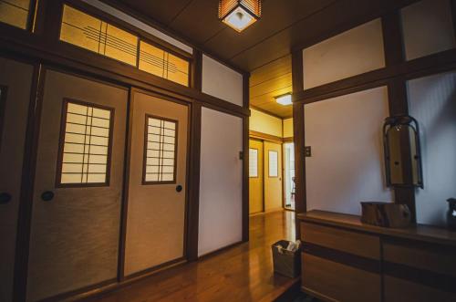 a hallway with doors andwindows in a room at 【佐渡/一棟貸切】オーシャンビュー古民家SeaSideStory椿 離れ in Sado