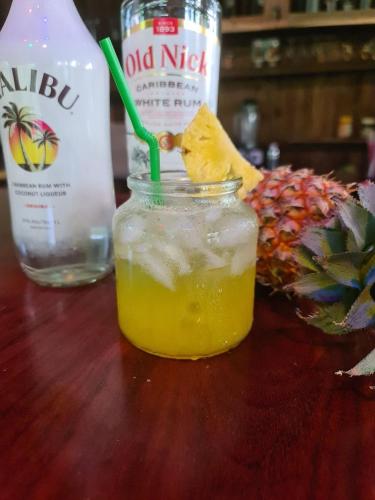 a drink in a jar on a table with a pineapple at Villa Romduol in Kampot