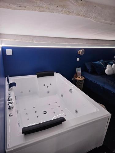 a large white bath tub in a room with a couch at Le Palais Secret 66 Loveroom in Saint-Féliu-dʼAvall