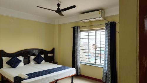 a bedroom with a bed and a window at HOTEL NILADRII GALAXY in Siliguri