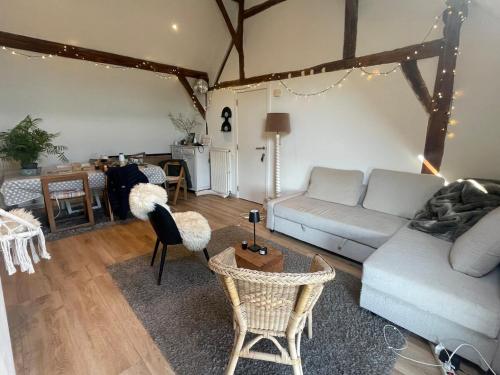 a living room with a couch and a table at Petit duplex cosy coup de coeur, dans ferme de charme du 18 è siècle au milieu des champs in Bossut-Gottechain