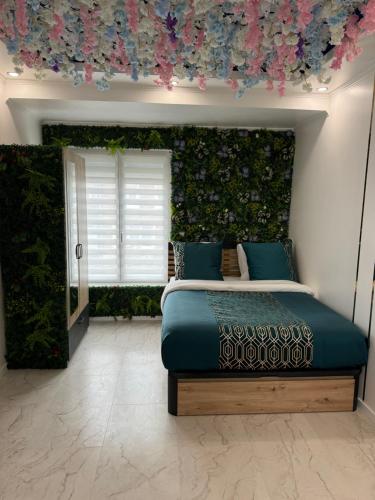 - une chambre avec un lit orné d'un mur fleuri dans l'établissement Appartement moderne avec jacuzzi, à Lille