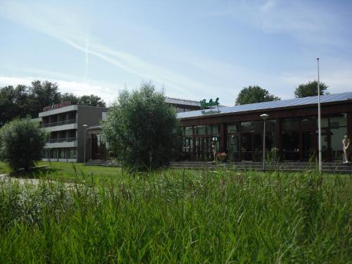 a building with a grassy field in front of it at Hotel Den Helder in Den Helder