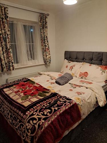 a bed with a blanket on it in a bedroom at Mekees Luxury Apartment Toronto Wing in Tipton