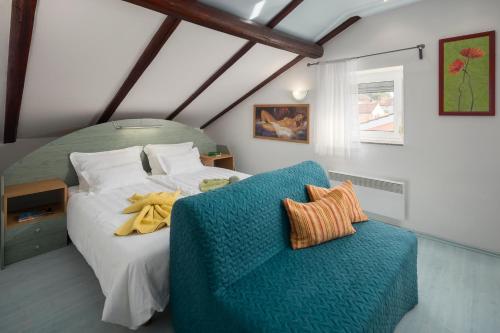 a bedroom with a bed and a blue chair at Villa Tina Porec in Poreč