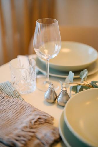 a table with plates and a wine glass on it at Air & Fair Apartment in Düsseldorf