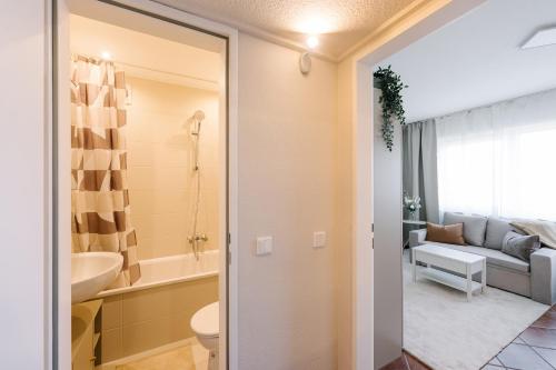 a bathroom with a toilet and a couch in a room at Air & Fair Apartment in Düsseldorf