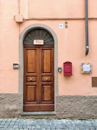 a wooden door on a building with a sign above it at Residenze del Bosco - Olivo in Tuscania