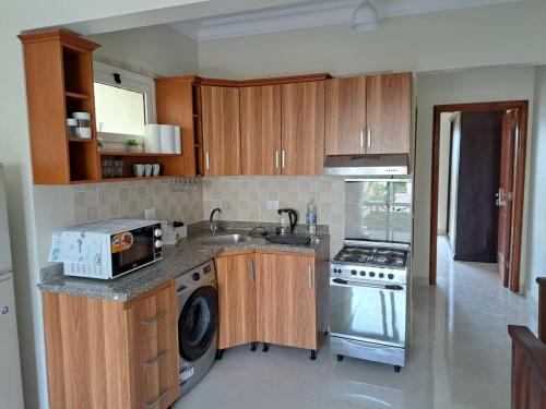 a kitchen with wooden cabinets and a sink and a stove at jo sunny lakes in Sharm El Sheikh
