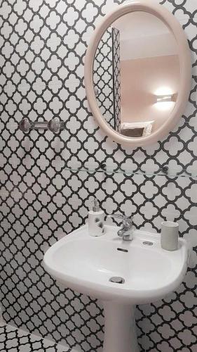 une salle de bain avec un lavabo blanc et un miroir dans l'établissement Maison Verveines, à Saint-Martin-dʼArdèche