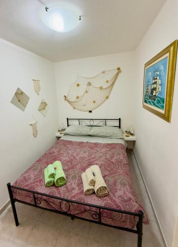 a bedroom with a bed with green shoes on it at Casa Gioia in Chioggia
