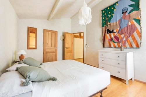 une chambre avec un lit blanc et un tableau au mur dans l'établissement Mas de 190m2 Climatisé avec Piscine et Cuisine d'été - 10 pers, à La Fare-les-Oliviers