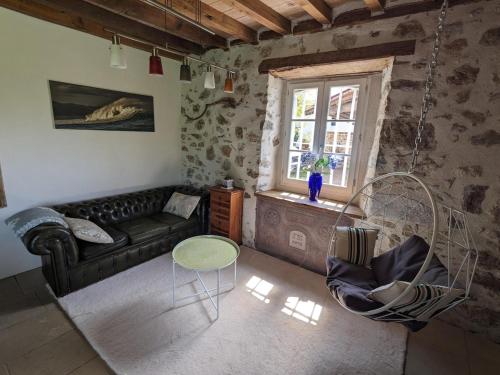 un salon avec un canapé, une table et une fenêtre dans l'établissement Grande Ferme Basque proche Montagnes et Plages, à Macaye