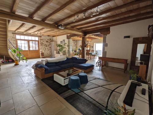 un salon avec un canapé bleu et une table dans l'établissement Grande Ferme Basque proche Montagnes et Plages, à Macaye