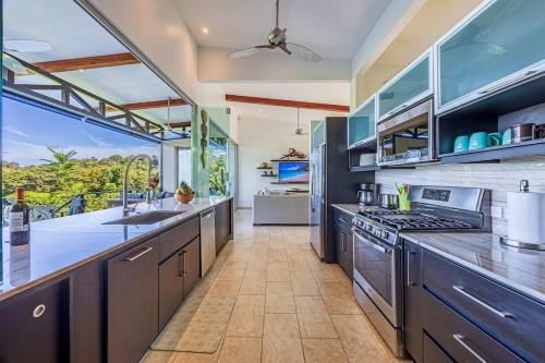 a kitchen with stainless steel appliances and a large window at Ocean View Villa With Pool and Spectacular Sunsets in Ballena
