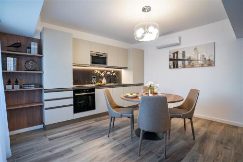 a kitchen and dining room with a table and chairs at Novos Luxury Suites in Bucharest