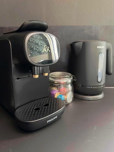 une cafetière assise sur un comptoir à côté d'une tasse dans l'établissement Grand logement familial - à Berck-Plage, à Berck-sur-Mer