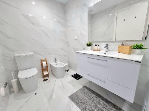 a white bathroom with a toilet and a sink at Modern Apartment in Portimão in Portimão