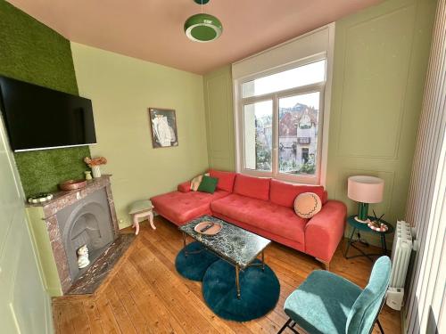 - un salon avec un canapé rouge et une cheminée dans l'établissement Grand logement familial - à Berck-Plage, à Berck-sur-Mer