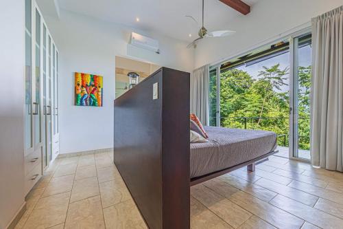 a bedroom with a bed and a large window at Ocean View Villa With Pool and Spectacular Sunsets in Ballena