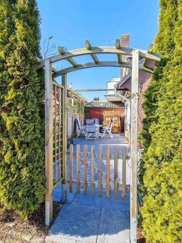 a wooden gate leading to a patio with a table at Friedels Wohlfühloase in Greetsiel