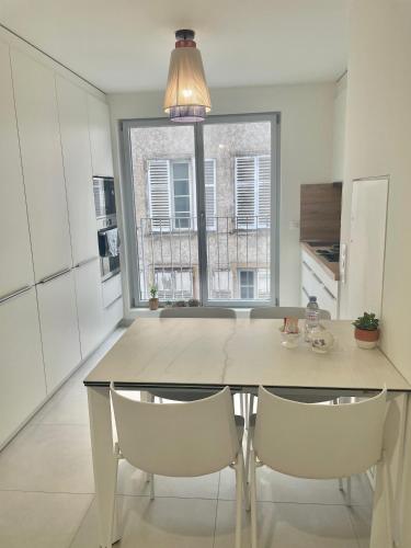 - une cuisine avec une table à manger et 2 chaises dans l'établissement Logement neuf entier Petite France, à Strasbourg