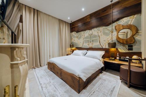 a bedroom with a large bed and a desk at Arctic Boutique Hotel in Korçë