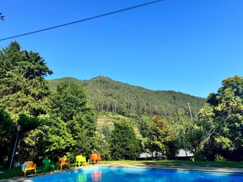 una piscina con sedie e una montagna sullo sfondo di casa do gaio a Geres