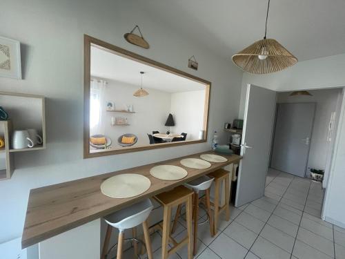 - une cuisine avec une table, des tabourets et un miroir dans l'établissement Joli appartement vue Pyrénées, à Pau