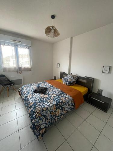 une chambre avec un lit avec une couette dans l'établissement Joli appartement vue Pyrénées, à Pau