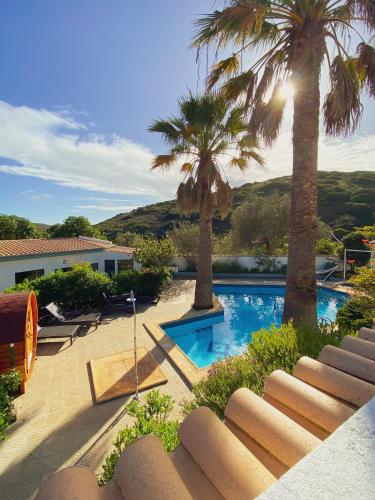 a resort with palm trees and a swimming pool at Casa Monki in Raposeira