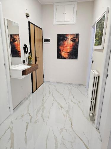 un corridoio bianco con pavimento in marmo e specchio di Casa di Theo a Pescara