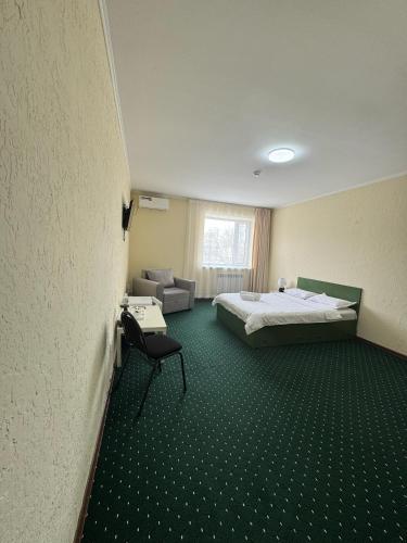 a hotel room with a bed and a chair at Turan in Karagandy