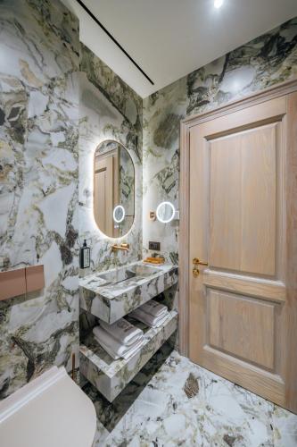 a bathroom with a sink and a mirror and a door at Arctic Boutique Hotel in Korçë