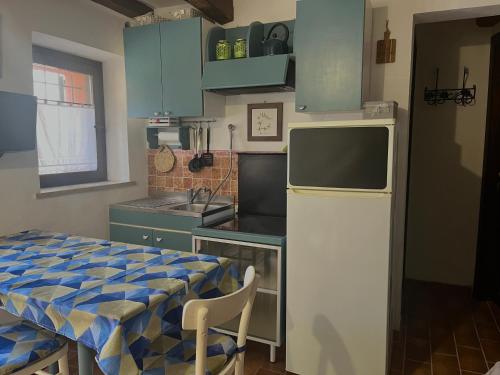 a small kitchen with a table and a refrigerator at Casa Lambertina in Senigallia