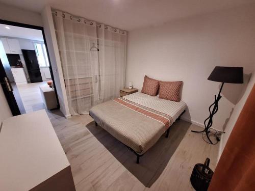 - une petite chambre avec un lit et une lampe dans l'établissement Charmant appartement lumineux, à Draguignan